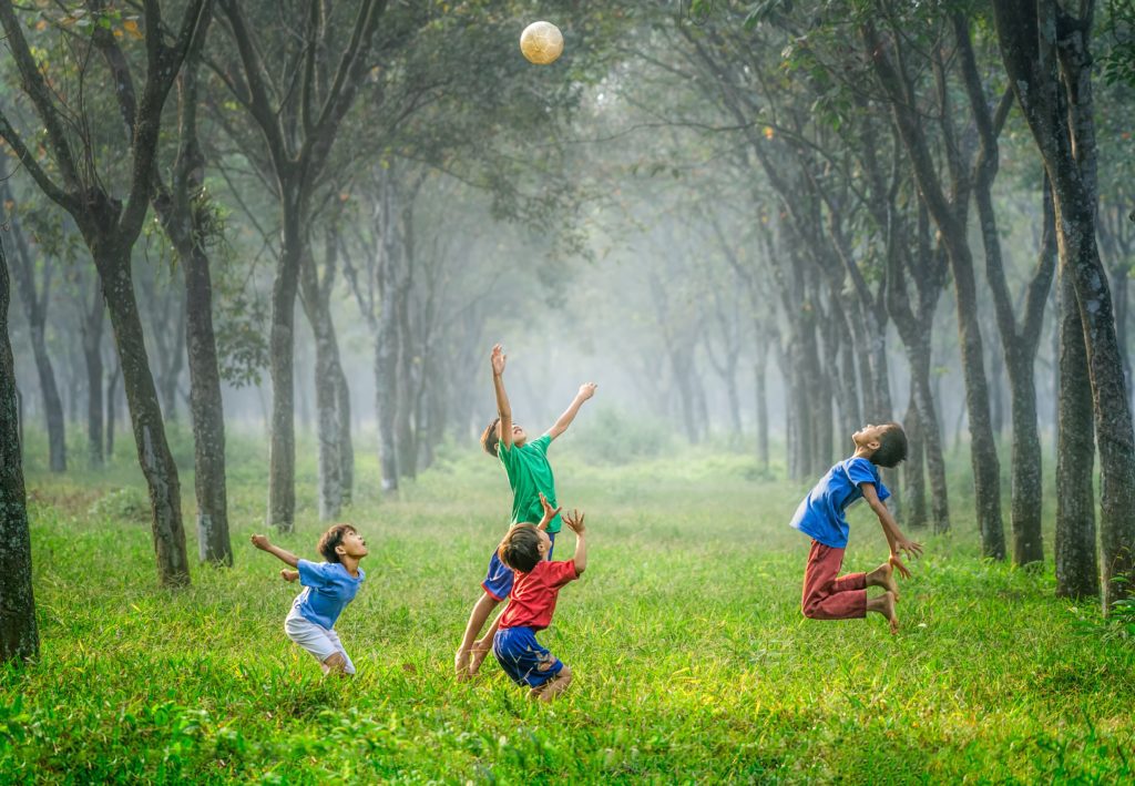 Children playing with ball in forest